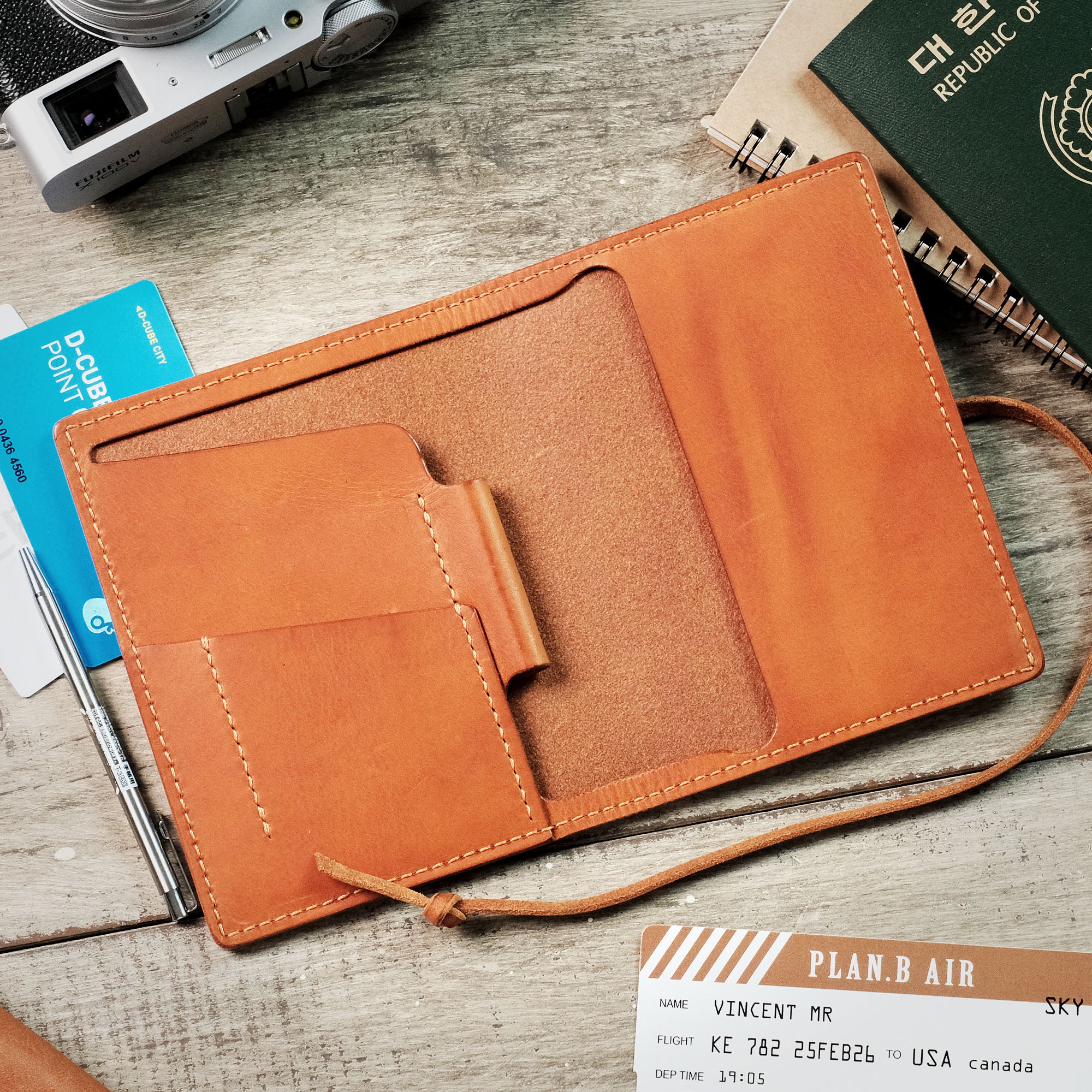 Interior view of the empty passport wallet, showcasing compartments for cards, documents, and a pen.