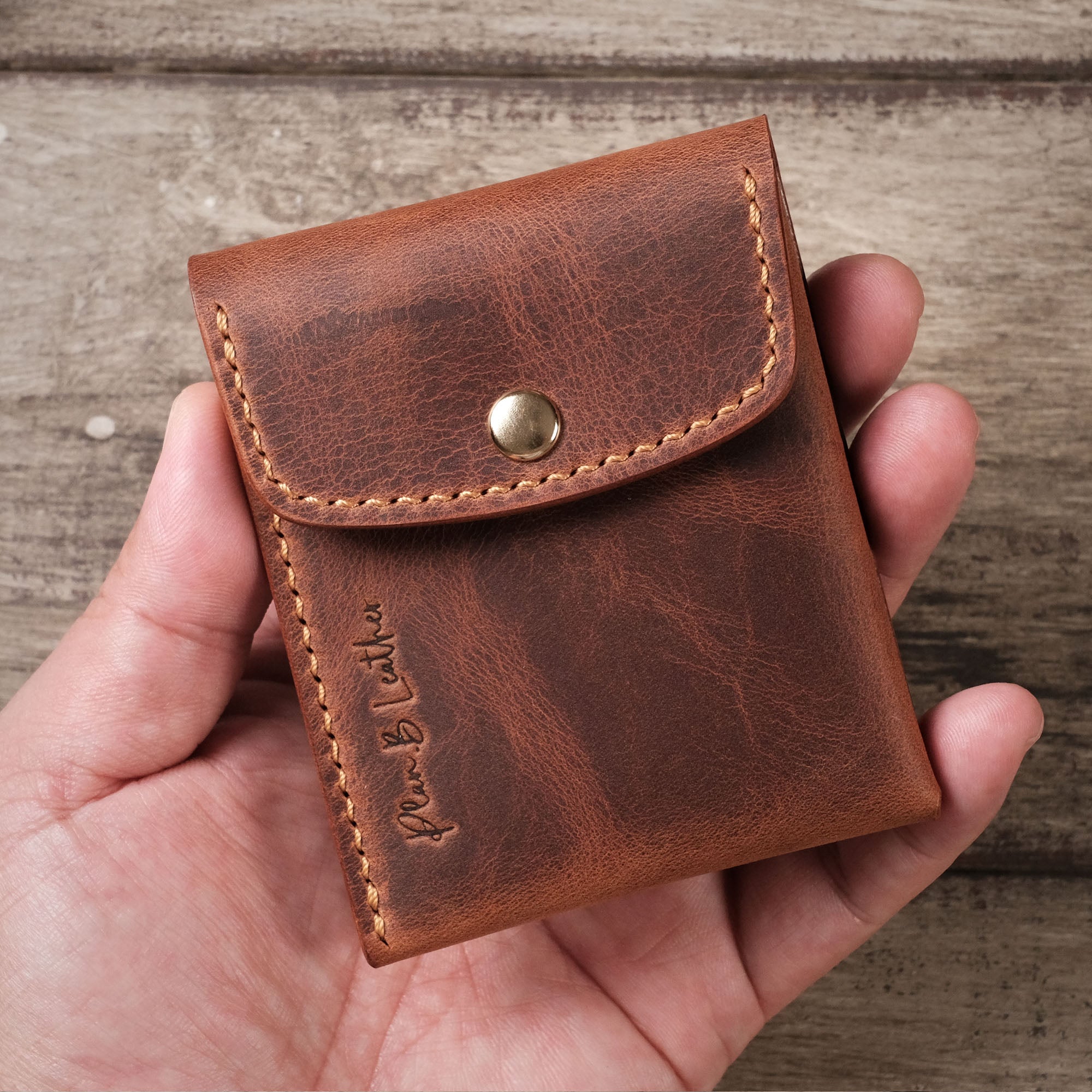 Person holding the Minimalist Wallet, showing its compact and lightweight design.