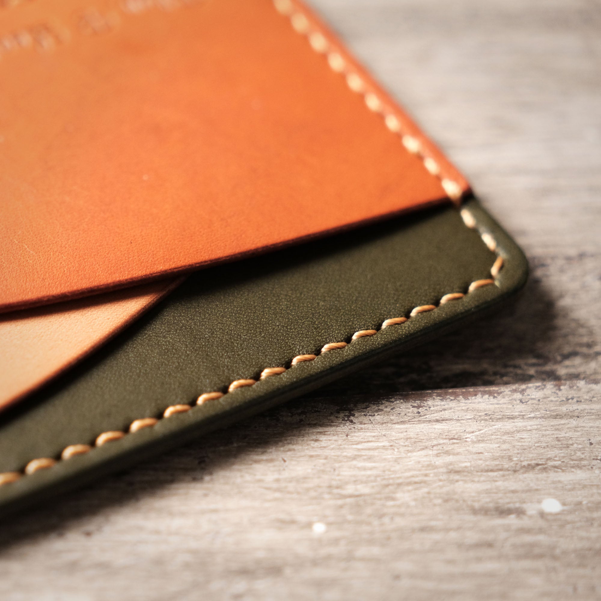 Zoomed-in view of the pocket line and stitching on the leather card holder.