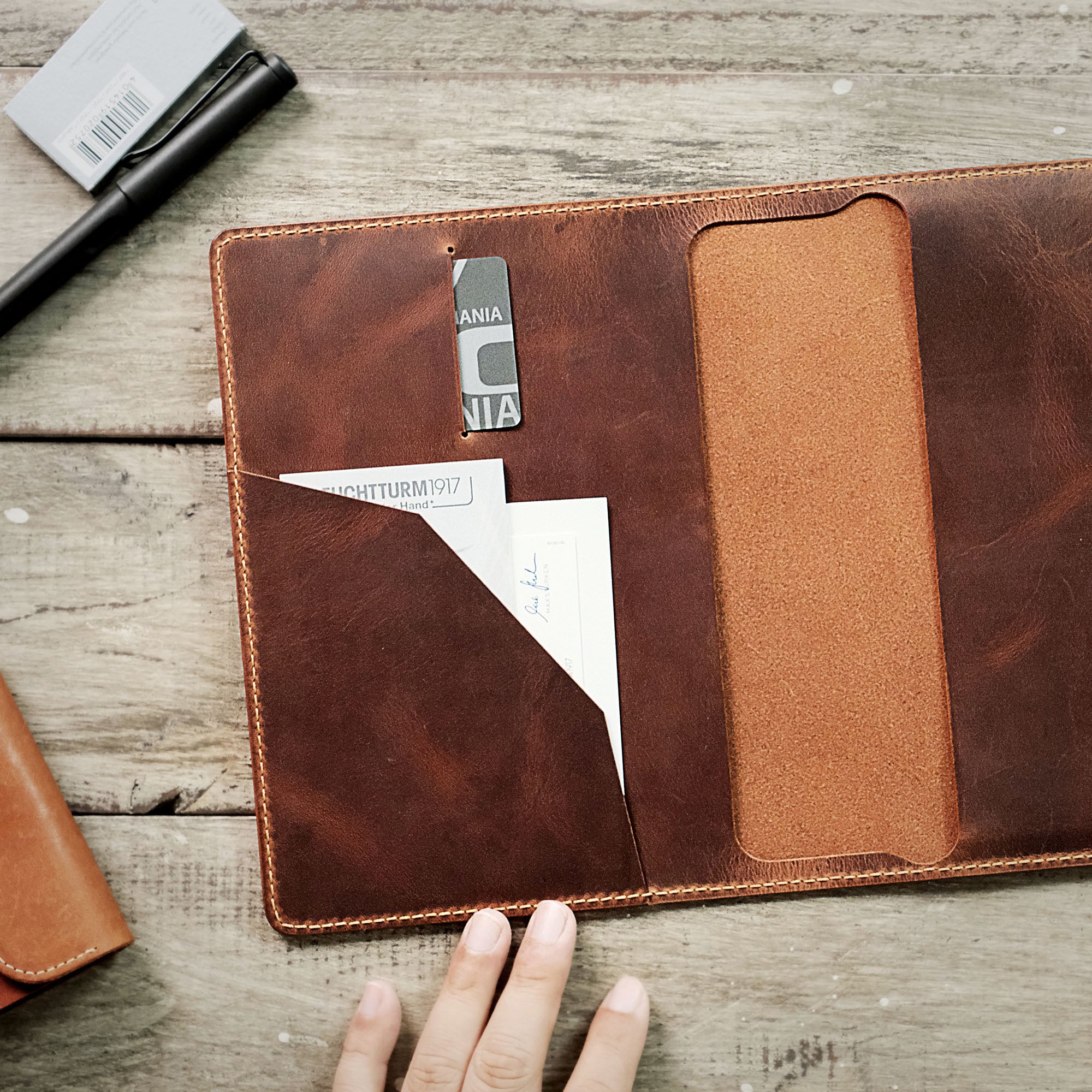 Minimalist leather cover with compartments for credit cards and a small notepad.