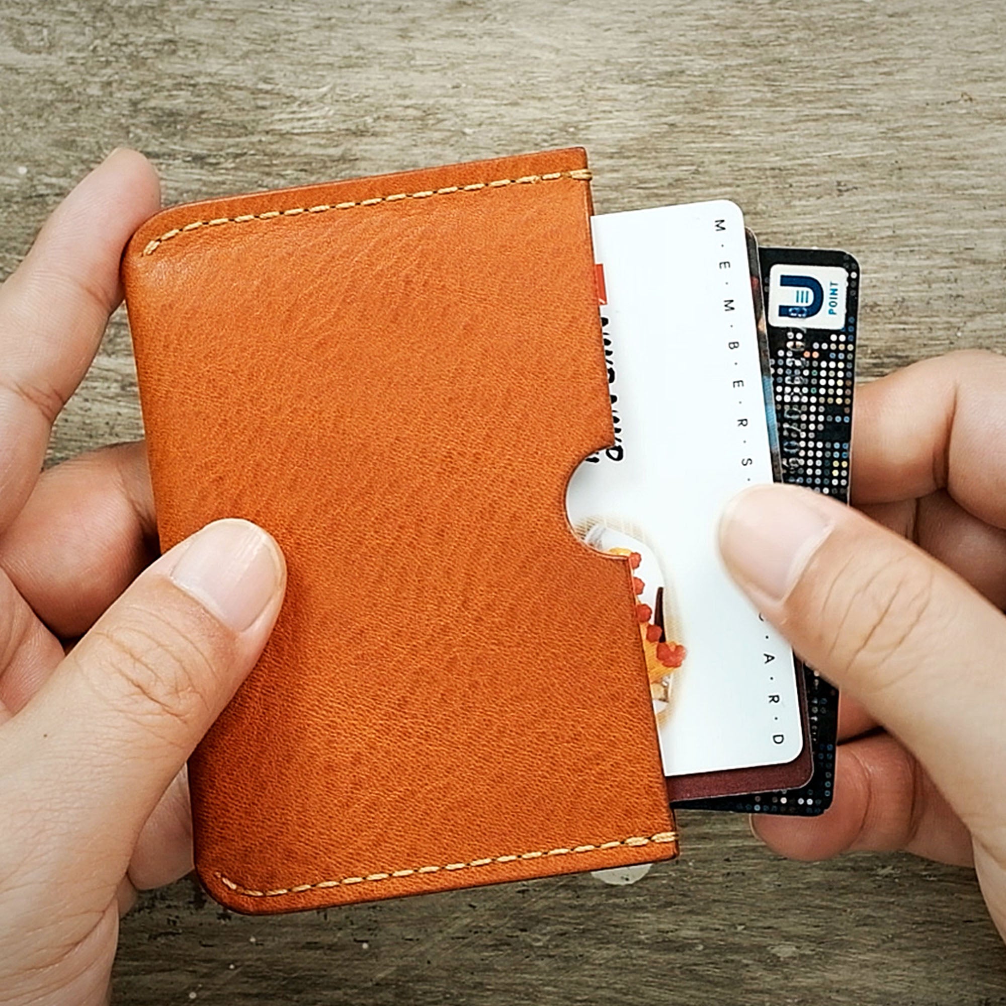 Detailed view of a card being inserted into the wallet, emphasizing storage capacity and ease of use.