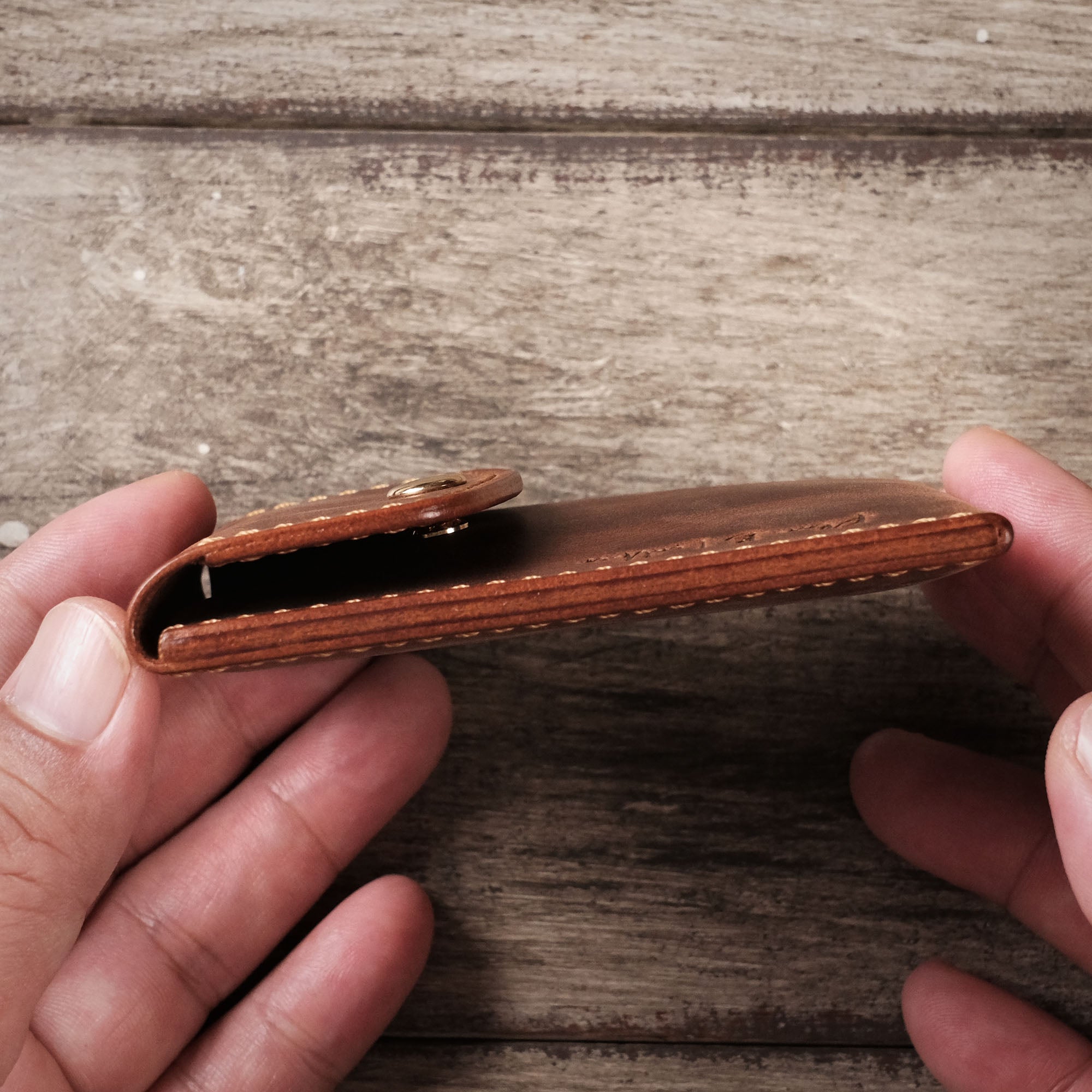 Detailed stitching on the left side of the slim, minimalist leather wallet.